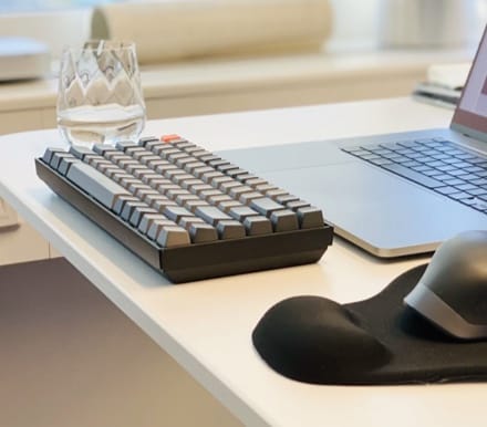 Keyboard and glass on wooden desktop